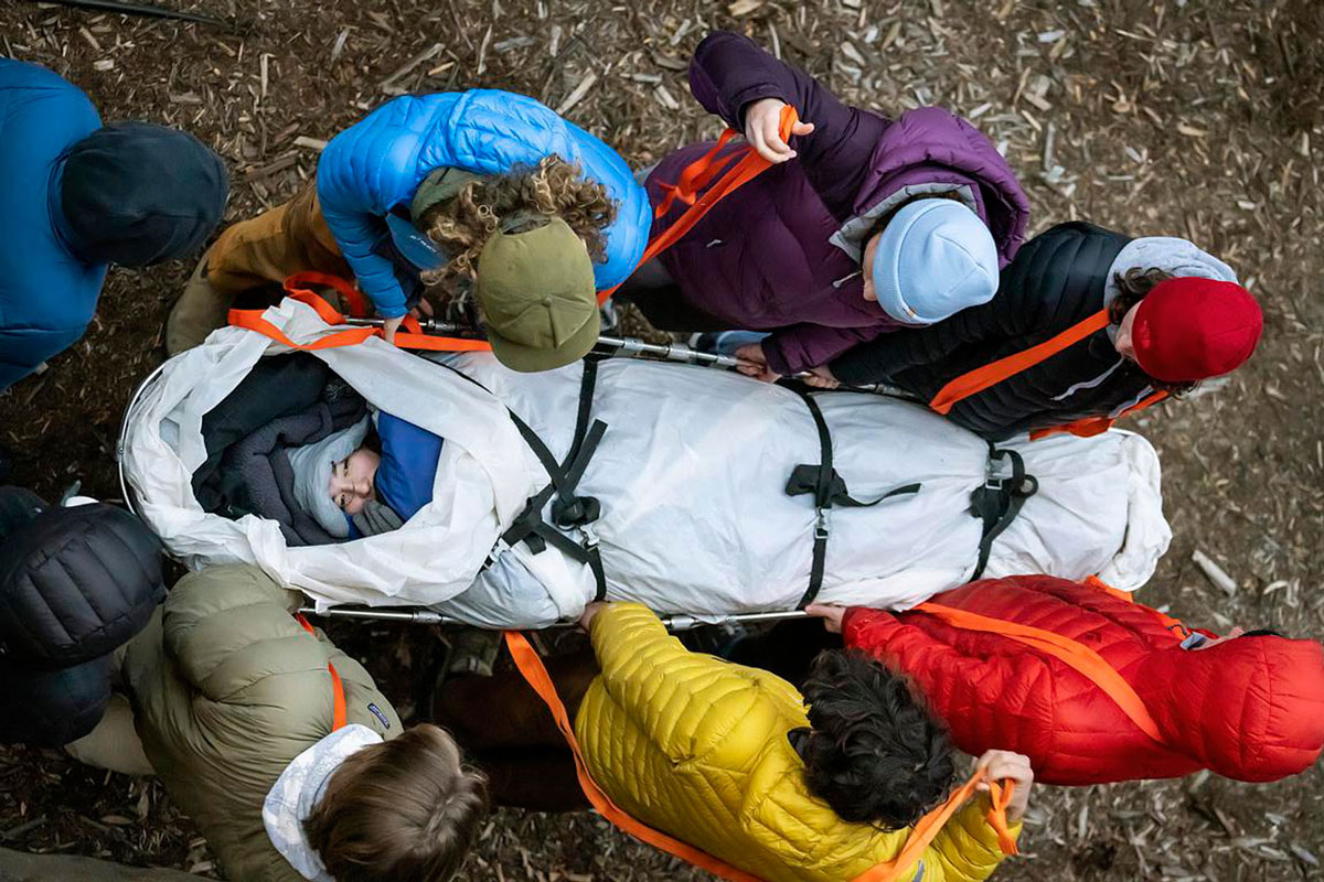 Sammy Park ’24 is in the basket during Wilderness First Responder and WFR Recertification courses (Spine Immobilization Practice) outside of Loomis Hall on 1/17/23. Part of course used mock scenarios designed to feel as real as possible, requiring students to act as though they are hurt or seriously injured. Photo by Lonnie Timmons III / Colorado College.